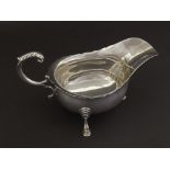 Georgian style 1920s silver sauceboat, with C-scroll handle and three cabriole hoof feet, maker