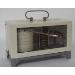Metal cased barograph, no. 2149 in a white glazed front casing with swing handle, 7" high, 10.5"