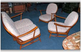 An Ercol Three Piece Cottage Suite with loose upholstered cushions. Comprising two seater sofa and