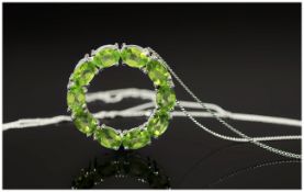 Peridot 'Circle of Life' Pendant, ten oval cut peridots, each of over .5ct, in a raised circular