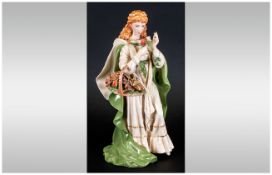 A Fine Hand Painted Ceramic Figure of a Young Woman In Flowing Robes, Holding a Basket of Roses.