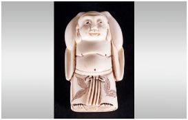 Japanese Late 19th Century Carved Ivory Netsuke In The Form Of A Man Standing with hands on head.