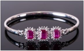 Ruby and White Topaz Bangle, three large octagon cut rubies, the largest, to the centre front