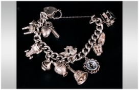 A Good Quality Vintage Silver Charm Bracelet Loaded with 12 charms on a silver Albert bracelet.