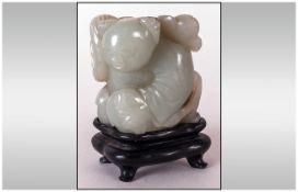 Small Chinese Green Jadeite Carving Of A Small Boy Carrying Fruit Over His Shoulder Sitting in a