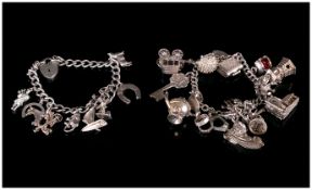 Two Silver Charm Bracelets, Loaded With 23 Charms, Both With Padlock Fasteners And Safety Chains,