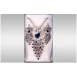 Blue and White Crystal 'Peacock' Necklace and Earrings Set,  comprising a stylised peacock pendant