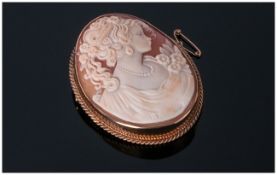 A Fine 9 carat Oval Framed Shell Cameo Brooch with portrait of a young woman in early 20thC dress.