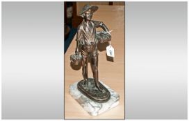 A 20th Century French Bronze Figure Of A Young Fisher Boy carrying baskets of fish. Raised on a