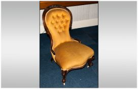 Victorian Nursing Chair with walnut frame. Over stuffed upholstery in gold colour. On castor feet.