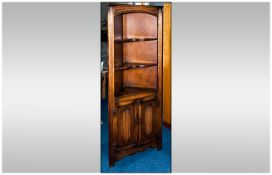 A Reproduction Oak Jacobean Style Corner Cupboard of small proportions with three shelves and two