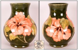 Moorcroft Coral Hibiscus Baluster Vase, the coral flowers on a green ground; 9.5 inches high; Potter
