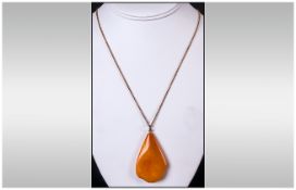 A Large Amber Pendant Drop On 9ct Gold Chain 24'' total length. The natural Amber of good colour.