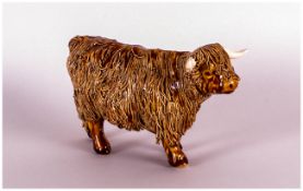 A Signed Ceramic Figure of a Highland cow, stands 4 inches high.