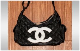 Fashion Handbag together with a pair of  sunglasses.  The bag is quilted black with the