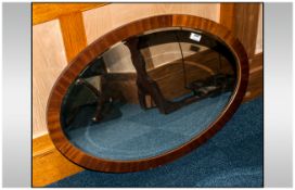 Oval Mirror with wood frame and bevelled glass. 32 inches wide.