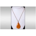 A Large Amber Pendant Drop On 9ct Gold Chain 24'' total length. The natural Amber of good colour.