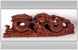 A Chinese Wood Carving of a Mythical Dragon and Flaming Pearl. 17.5 Inches In Length.