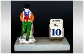 A Small Figural and SIlver Desk Calendar. The Ceramic Artful Dodger Figure and Sterling Silver