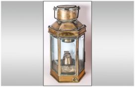An Antique Brass Coaching Paraffin Lamp with a locking device to the front, of hexagonal shape, with
