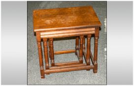 Reproduction Nest Of Three Oak Tables on turned column legs with cross stretchers.