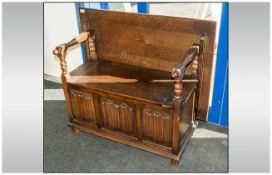 Oak Reproduction Monks Bench In The Jacobean Style, with a lift up lid seat, with turned arm