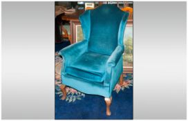A Queen Anne Style Wing Arm Chair with a loose cushion seat on scrolling arms and Queen Anne Legs,