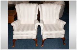 A Pair of Queen Anne Style Wing Arm Chairs, over stuffed, with a loose fitting cushion, with rolling