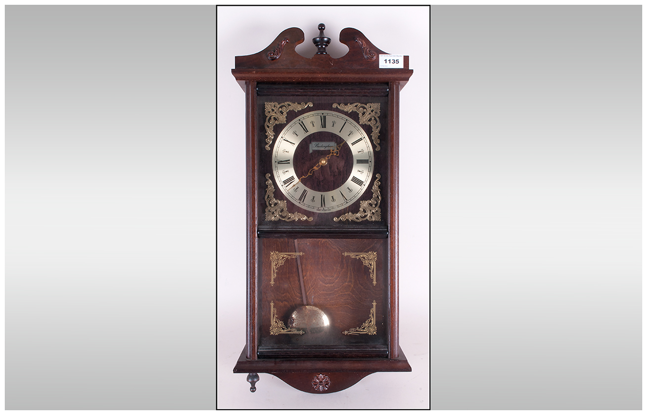 Reproduction Brass Faced Wall Clock with exposed pendulum, with a glazed front. Makers name,