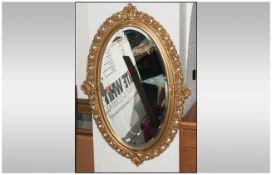 A Gilt Framed Oval Shaped Mirror with bevelled edge made by Peer Art. 22 inches wide by 33 inches