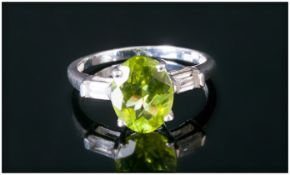 Peridot and White Topaz Ring, an oval cut Chinese peridot of 2.25cts and of good colour, set in