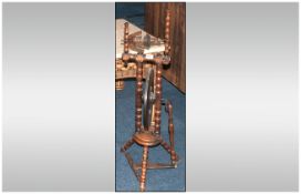An Antique Welsh Type Treen Spinning Wheel supported on spindled arms and legs, with a solid
