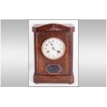 German Oak Cased Mantle Clock in the 1920's style with a round steel dial and exposed pendulum