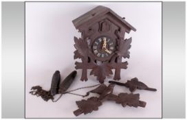 Black Forest Type Cuckoo Clock on two iron pine cone weights, with a carved bird pediment.