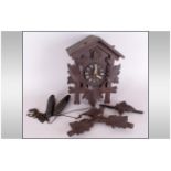 Black Forest Type Cuckoo Clock on two iron pine cone weights, with a carved bird pediment.