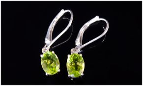 Pair of Peridot Drop Earrings, a total of 2.75cts of Chinese peridot, in two oval cut solitaires,