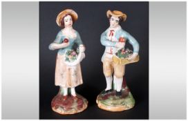 Pair of Staffordshire Figures, a lady with apples collected in her apron, and a gentleman with a box