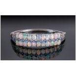 Opal and Tanzanite Bangle, comprising two rows of oval cut cabochon opals highlighted with a row
