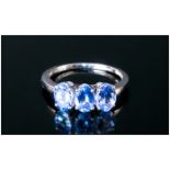 Tanzanite Trilogy Ring, three oval cut tanzanites totalling 1.75cts, set in a row in 9ct white gold;