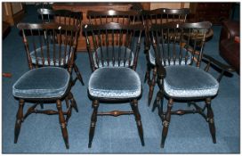 A Set of Dark Stained Spindle Back Chairs with shaped backs.