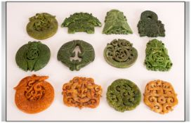 A Collection of Oriental Coloured Stone Roundels, carved with dragons, fish and mythological