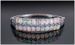 Opal and Tanzanite Bangle, comprising two rows of oval cut cabochon opals highlighted with a row