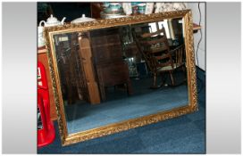 A Large Gilt Framed Mirror in the Traditional Roccoco Style of rectangular form and with a