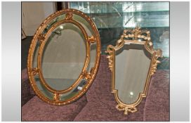 Two Decorative Gilt Framed Mirrors, comprising one large oval mirror 34'' in diameter & one