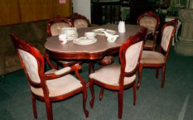 An Italian Style Stained Walnut Dining Table and 6 Chairs. The shaped top with a profusely inlaid