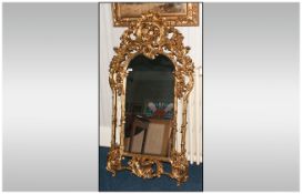 Gilt Mirror In The French Rococo Style with decorated side pillars. 56x27''