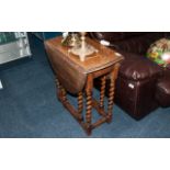 Small Sized Oak Edwardian Drop Leaf Table with barley twist legs, supported by a stretcher with oval