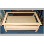 Modern Cream Coloured Coffee Table with Glass Top and Shelf Below. 47 x 27 Inches.