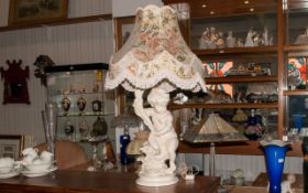 A Large Decorative Plaster Base Lamp in the form of a Putti holding a cornea copia, large floral