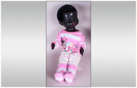 Pedigree Black Doll, black plastic body with moveable limbs and  glass eyes. Dressed in pyjamas. c